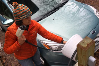 In this Thursday, April 6, 2017 photo, Sunita Halasz shows how she charges her electric car at her home in Saranac Lake, N.Y. Halasz has tips for 'driving electric' along the lonely New York Adirondack Mountains roads: learn where the charging stations are, bring food and books for the kids during three-hour recharges, use the defroster in 10-second bursts since it sucks battery life, and have a backup plan.