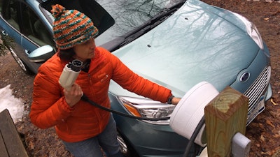 In this Thursday, April 6, 2017 photo, Sunita Halasz shows how she charges her electric car at her home in Saranac Lake, N.Y. Halasz has tips for 'driving electric' along the lonely New York Adirondack Mountains roads: learn where the charging stations are, bring food and books for the kids during three-hour recharges, use the defroster in 10-second bursts since it sucks battery life, and have a backup plan.