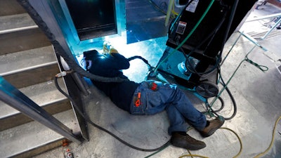 In this March 30, 2017 photo, a worker welds near a stairwell inside one of several ferryboats being built for a new fleet of ferries for New York City, at the Metal Shark Shipyard in Franklin, La. The city is investing $335 million in the Citywide Ferry Service, betting that it will attract millions of passengers in waterfront neighborhoods in Brooklyn, Queens and the Bronx that are now a distant walk from overcrowded subways.