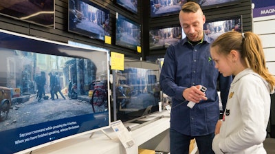 In this photo taken Saturday, April 15, 2017, Salome Sigurjonsdottir, 10, tests a voice-controlled television in an electronics store in Reykjavik. Sales assistant Einar Dadi said none of his TVs understood Icelandic. The revered Icelandic language, seen by many as a source of identity and pride, is being undermined by the widespread use of English both for mass tourism and in the voice-controlled artificial intelligence devices coming into vogue.