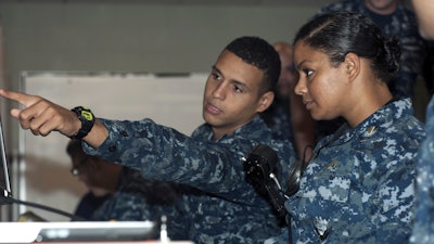 In this May 16, 2012, file photo, released by the U.S. Navy, Petty Officer 3rd Class DonPaul Mitchell, left, assigned to the guided-missile submarine USS Georgia, instructs Ensign Tabitha Strobel, Georgia's main propulsion assistant, in a trainer at Naval Submarine Base Kings Bay in Georgia.
