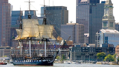 In this Aug. 29, 2014, file photo, the USS Constitution is towed through Boston Harbor past Boston's financial district skyline with its topsails unfurled. The warship nicknamed Old Ironsides, the world's oldest commissioned ship still afloat, is nearing the end of a two-year restoration in dry dock at the Charlestown Navy Yard. It is slated to return to the waters in late July 2017.