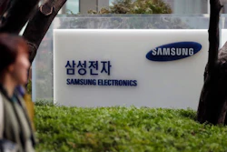 In this March 24, 2017 photo, a woman walks past a logo of Samsung Electronics in Seoul, South Korea. Samsung Electronics said Friday, April 7, 2017 its first-quarter profit jumped 48 percent likely due to smartphone component sales.