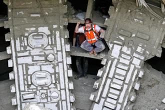 A worker pumps his fists as he stands between the cutting blades of a massive tunneling machine after it broke through a five-foot wide concrete wall to complete boring for the State Route 99 highway, Tuesday, April 4, 2017, under Seattle. After tunneling more than 9,000 feet and building an outer tunnel wall as it moved forward, the boring machine finished digging what will be a two-mile, double-decker traffic tunnel to replace the Alaskan Way viaduct, damaged in an earthquake in 2001.