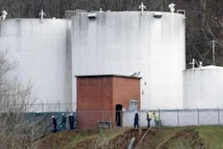 In this Monday, Jan. 13, 2014, file photo, workers inspect an area outside a retaining wall around storage tanks where a chemical leaked into the Elk River at Freedom Industries storage facility in Charleston, W.Va. A federal judge is expected to hear details, Monday, Oct. 31, 2016, of a potential tentative settlement between a water company and plaintiffs who sued over the company's handling of a 2014 chemical leak in southern West Virginia.