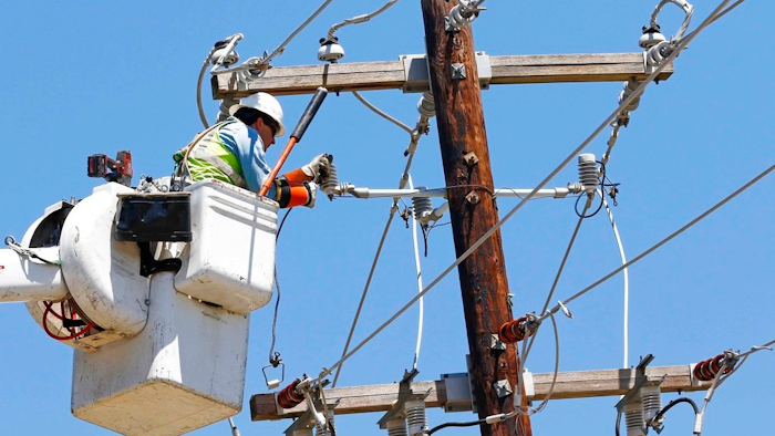 In this Monday, May 1, 2017, file photo, a Greenwood Utilities lineman works on power lines in Durant, Miss., as cleanup continues from a possible tornado that swept through the rural community a day earlier. On Tuesday, May 16, 2017, the Federal Reserve reports on industrial production for April.