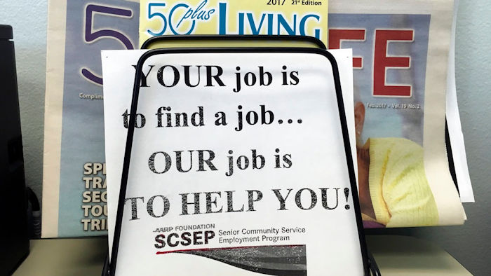 In this May 18, 2017, photo, a sign for the Senior Community Service Employment Program at the AARP Foundation in Harrisburg, Pa. The half-century-old Senior Community Service Employee Program, is a training and placement program underwritten by taxpayers aimed at putting older Americans back into the workforce. President Donald Trump says there are too few participants who find work that’s not paid for by the federal government. This week, he proposed deleting the $434 million program from the federal budget _ a strike at a piece of President Lyndon Johnson’s “war on poverty.”