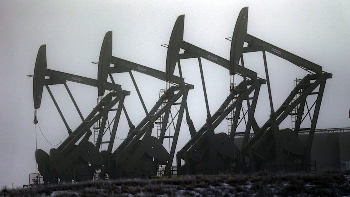 In this Dec. 19, 2014, file photo, oil pump jacks work in unison in Williston, N.D. In the heart of North Dakota's oil patch, there are hundreds of more jobs than takers. No longer is it easy to find a hotel room or a table at a restaurant. More than two years after the state's unprecedented oil bonanza fizzled, North Dakota is experiencing a sort of boomlet with an increase in drilling that has brought oil production back up to more than 1 million barrels daily.