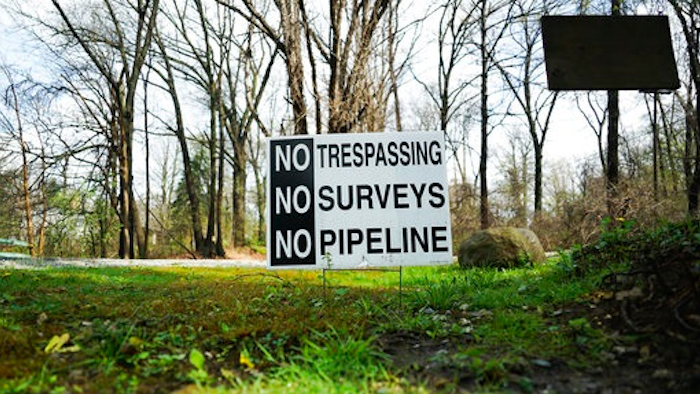 In this April 20, 2017 photo, a sign opposing a proposed pipeline sits in the front yard of a house in Green, Ohio. The town has hired a law firm to stop the pipeline from being built through the community.