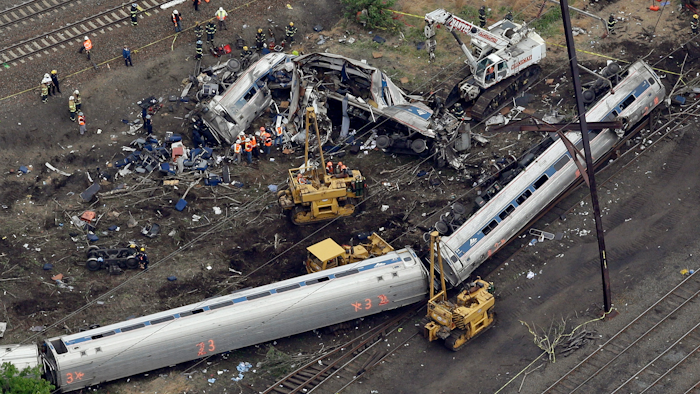 In this file photo, emergency personnel work near the wreckage of a New York City-bound Amtrak passenger train following a derailment that killed eight people and injured about 200 others in Philadelphia.