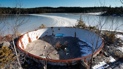 In this Wednesday, Dec. 21, 2016 photo, a deteriorating tank sits on the site of the Callahan Mine in Brockville, Maine. The former open pit copper and zinc mine is now a federal Superfund site. Mining companies that once pursued precious metals have abandoned half a million mines across the country and, thanks to decades of lax regulations, left the bill to taxpayers.