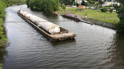 A barge carrying Chinese-made beer fermentation tanks floats down the Erie Canal in Clyde, N.Y., toward the Genesee Brewery in Rochester, N.Y. Some politicians are irritated that the Rochester brewery, which receives state economic development funding, bought beer fermentation tanks from China that could have been produced in New York.