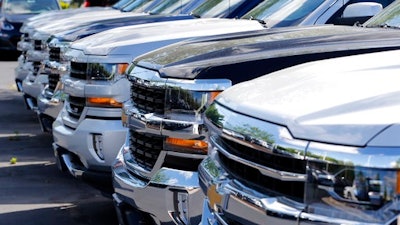 Chevrolet trucks are lined up at a Chevrolet dealership in Richmond, Va. Analysts expect the auto industry to post a fourth straight month of lower sales as the pace of sales cools after last year's record.