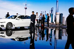 In this April 19, 2017, file photo, visitors look at a BMW 5 series vehicle displayed at the Auto Shanghai 2017 show at the National Exhibition and Convention Center in Shanghai, China. The China Association of Automobile Manufacturers said Thursday, May 11, 2017 that China's auto sales shrank in April as demand for most types of vehicles wilted.