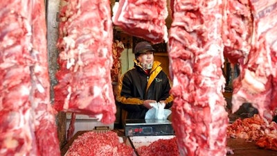 In this Jan. 22, 2003 file photo, a Chinese shopkeeper stands behind a row of beef products at an open air market in Beijing, China. China will finally open its borders to U.S. beef while cooked Chinese poultry is closer to hitting the American market as part of a U.S.-China trade agreement. Trump administration officials hailed the deal as a significant step in their efforts to boost U.S. exports and even America's trade gap with the world's second-largest economy.