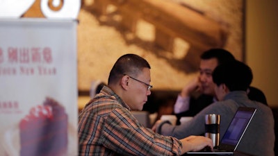 In this Feb. 16, 2015 file photo, a man surfs Internet on his laptop computer at a Starbuck cafe in Beijing. Security researcher say China's fondness for pirated software left it especially vulnerable to the latest global cyberattack. Beijing has tolerated rampant use of unlicensed software copies despite repeated promises to crack down and warnings by industry groups that China is leaving itself open to being hurt by malicious code.