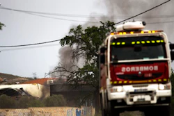 A firefighter truck leaves as smoke rises from a factory after several explosions, in Arganda del Rey, outside Madrid, Thursday, May 4, 2017. A fire and several explosions ripped through an industrial waste treatment factory Thursday in a town near Madrid, sending 30 people to the hospital for treatment and forcing the immediate evacuation of nearby schools and offices, officials said.