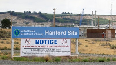 In this July 9, 2014, file photo, a sign informs visitors of prohibited items on the Hanford Nuclear Reservation near Richland, Wash. A new report says Congress should consider authorizing the Department of Energy to use grout to stabilize some of Hanford's radioactive waste, rather than a more expensive plan to turn it into glass.