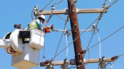 In this Monday, May 1, 2017, file photo, a Greenwood Utilities lineman works on power lines in Durant, Miss., as cleanup continues from a possible tornado that swept through the rural community a day earlier. On Tuesday, May 16, 2017, the Federal Reserve reports on industrial production for April.