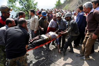 In this picture released by the Tasnim News Agency, miners and rescue personnel carry an injured mine worker after a coal mine explosion, near Azadshahr in northern Iran, Wednesday, May, 3, 2017. Iranian state media said Wednesday that a large explosion struck the coal mine, trapping dozens of miners and killing at least two. Ambulances, helicopters and other rescue vehicles raced to the scene on Wednesday in Golestan province as authorities worked to determine the scale of the emergency.