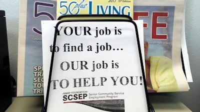 In this May 18, 2017, photo, a sign for the Senior Community Service Employment Program at the AARP Foundation in Harrisburg, Pa. The half-century-old Senior Community Service Employee Program, is a training and placement program underwritten by taxpayers aimed at putting older Americans back into the workforce. President Donald Trump says there are too few participants who find work that’s not paid for by the federal government. This week, he proposed deleting the $434 million program from the federal budget _ a strike at a piece of President Lyndon Johnson’s “war on poverty.”