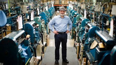 Don Rongione, President and Chief Operating Officer of Bollman Hat Company poses for a photograph with knitting machine used in the manufacturing of Kangol hats the Bollman Hat Company in Adamstown, Pa., Monday, May 1, 2017. When the famous hat brand moved into the Pennsylvania factory last year from China, executives with the Bollman Hat Co. billed it as an effort to create U.S. manufacturing jobs. “It has been certainly a bigger challenge than what we could've ever dreamed,” said Rongione.