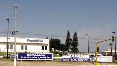 This April 28, 2017 photo shows a sign that says 'We're hiring' outside a Panasonic 'maquiladora' in an industrial park in Reynosa, Mexico, across the border from McAllen, Texas. A long-time factory worker said he worried that if maquila jobs decrease, the unemployed would fill the ranks of a drug cartels that control Mexican border towns.