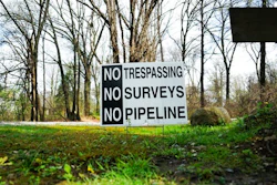 In this April 20, 2017 photo, a sign opposing a proposed pipeline sits in the front yard of a house in Green, Ohio. The town has hired a law firm to stop the pipeline from being built through the community.