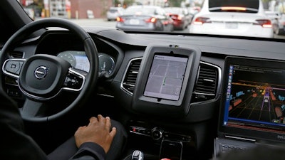 In this Tuesday, Dec. 13, 2016, file photo, an Uber driverless car waits in traffic during a test drive in San Francisco. In just a few years, well-mannered self-driving robotaxis will share the roads with reckless, law-breaking human drivers. The prospect is causing migraines for the people developing the robocars and is slowing their development. But experts say eventually the cars will coexist with human drivers on real roads.