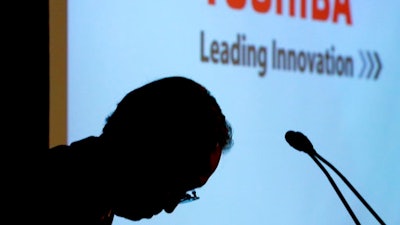 In this April 11, 2017 file photo, Toshiba Corp.'s President Satoshi Tsunakawa bows during a press conference at the company's headquarters in Tokyo. Money-losing Japanese electronics company Toshiba is sparring with its U.S. joint venture partner Western Digital over the planned sale of Toshiba's computer-chip business. Toshiba warned Western Digital to stop interfering, according to letters seen Tuesday, May 9, by The Associated Press. The letters from the company's lawyers, dated May 3, accused Western Digital of 'improper' interference.