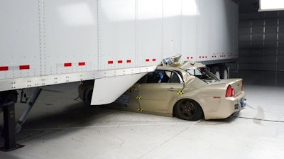 In this April 2017 photo provided by the Insurance Institute for Highway Safety, a Chevrolet Malibu underrides a tractor-trailer in a 35 mph crash test. The trailer has an aerodynamic skirt but no underride guard. Federal law requires big trucks to have rear underride guards, which stop cars from traveling underneath the truck in an accident. But the government doesn’t require side guards. The Insurance Institute for Highway Safety says side guards could prevent hundreds of traffic deaths per year.