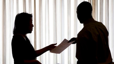 In this June 23, 2014, file photo, a recruiter, at left, takes the resume of an applicant during a job fair, in Philadelphia. On Thursday, May 11, 2017, the Labor Department reports on the number of people who applied for unemployment benefits the week before.