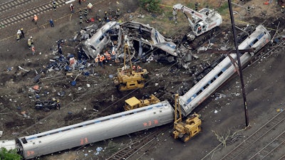 In this file photo, emergency personnel work near the wreckage of a New York City-bound Amtrak passenger train following a derailment that killed eight people and injured about 200 others in Philadelphia.