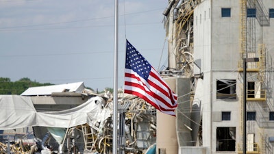 An American flag flies at half-staff in front of the Didion Ethanol Plant in the Village of Cambria, Wis., Friday, June 2, 2017. An explosion at the next-door Didion Milling Plant, background, on Wednesday night killed three employees and injured about a dozen others.