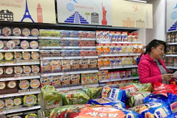 In this file photo taken Friday, March 17, 2017, a vendor takes stock of imported food at a mall in Beijing, China. Food exporters including the United States and Europe are stepping up pressure on China to scale back plans for intensive inspections of imports that they say will hamper access to its fast-growing market.
