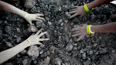 In this Monday, Dec. 14, 2015, file photo, Indian women use bare hands to pick reusable pieces from heaps of used coal discarded by a carbon factory in Gauhati, India. The world’s biggest coal users - China, the United States and India - have boosted coal mining in 2017, in an abrupt departure from last year’s record global decline for the heavily polluting fuel and a setback to efforts to rein in climate change emissions.
