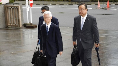 Tsunehisa Katsumata, center, former chairman of Tokyo Electric Power Co. (TEPCO), accompanied by his lawyers, arrives at Tokyo District Court for a trial in Tokyo Friday, June 30, 2017. Three former executives of TEPCO, including Katsumata, are going on trial for alleged negligence in the 2011 Fukushima nuclear disaster. The trial is the first to consider whether the utility can be held criminally responsible.