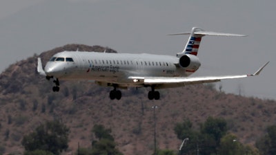 An American Eagle jet is seen through heat ripples as it lands at Sky Harbor International Airport in Phoenix. American Airlines cancelled dozens flights out of Phoenix due to extreme heat.