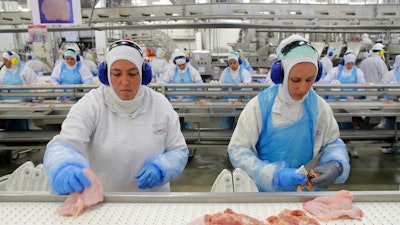 In this March 21, 2017 file photo, workers prep poultry at the meatpacking company JBS in Lapa, Brazil. In a major blow to Brazil, the United States on Thursday, June 22, 2017 announced the immediate suspension of all imports of beef products from Latin America’s largest nation because of safety concerns.