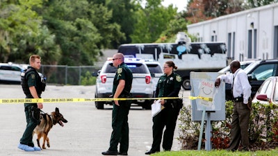 Law enforcement personnel investigate the scene where the scene where multiple people were killed in a shooting at a business in Orlando, Monday, June 5, 2017.