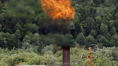 In this June 15, 2005 file photo, flames from methane burning at the landfill in Coventry, Vt. The Trump administration is delaying two Obama-era regulations aimed at restricting harmful methane emissions from oil and gas production.