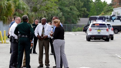 Authorities confer near the scene of a shooting where they said there were multiple fatalities in an industrial area near Orlando, Fla., Monday, June 5, 2017. The Orange County Sheriff's Office said on its official Twitter account that the situation has been contained.