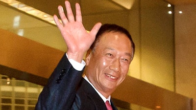 In this Sunday, Feb. 24, 2013, file photo, Foxconn Technology Group Chairman Terry Gou waves as he arrives at a hotel in Beijing. Gou says there is ‘still a chance’ the Taiwanese electronics giant might be able to buy Toshiba’s chip business despite the Japanese company’s choice of another bidder as its preferred buyer.