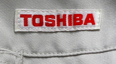 In this Thursday, June 15, 2017, photo, the logo of Toshiba Corp., Japan's electronics and energy company, is seen on a worker's jacket in Yokosuka, near Tokyo. Tokyo-based Toshiba, whose U.S. nuclear unit Westinghouse Electric Co. filed for bankruptcy protection in March, said Friday it received an extension until Aug. 10 to give its earnings report for the fiscal year that ended in March.