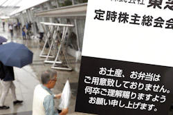 Toshiba shareholders arrive at the venue for the annual shareholders' meeting in Chiba, east of Tokyo, Wednesday, June 28, 2017. Japanese electronics and energy giant Toshiba has delayed its deadline for reaching an agreement on selling its lucrative computer memory chip business. The company said Wednesday negotiations were continuing on a 2 trillion yen ($18 billion) deal with a consortium led by a Japanese government-backed fund. Tokyo-based Toshiba had hoped to have an agreement in time for Wednesday's shareholders meeting. The sign reads: 'Toshiba Corporation. The venue for the annual shareholders' meeting. Please do understand that we do not provide you souvenirs or lunch boxes.'