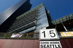 In this June 2, 2014, file photo, a sign that reads '15 Good Work Seattle' is displayed below Seattle City Hall, right, and the Columbia Center building, left, after the Seattle City Council passed a $15 minimum wage measure. A new study says Seattle's $15-an-hour minimum wage law has boosted pay for restaurant industry workers without costing jobs. The report, from the University of California at Berkeley, is certain to add to the debate as activists around the country push for increases in local, state and federal minimum wages.