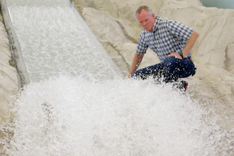 In this Friday, June 16, 2017, photo, hydraulic engineering professor Michael Johnson looks at the water flow on a replica of the Oroville Dam spillway at Utah State University's Water Research Laboratory, in Logan, Utah. California water officials are relying on key hydrology tests being performed on the replica of the spillway to pinpoint what repairs will work best at the tallest dam in the U.S for a spillway that was torn apart in February.