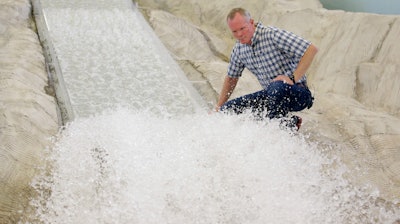 In this Friday, June 16, 2017, photo, hydraulic engineering professor Michael Johnson looks at the water flow on a replica of the Oroville Dam spillway at Utah State University's Water Research Laboratory, in Logan, Utah. California water officials are relying on key hydrology tests being performed on the replica of the spillway to pinpoint what repairs will work best at the tallest dam in the U.S for a spillway that was torn apart in February.