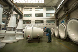 In this Nov. 9, 2015 photo, a worker inspects wind turbine parts at a Goldwind wind turbine factory in Beijing. Increasing amounts of green energy have gone unused in China as it struggles to integrate wind and solar power into a dated electricity network dominated by coal.