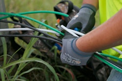 In this Thursday, June 22, 2017 photo, Noah Zeigler works at installing new aluminum wiring at a streetlight in Tulsa, Okla. The city has lost 33 miles of streetlight wiring to thieves stealing copper wire.